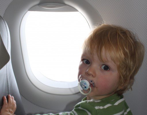 Kind im Flugzeug am Fenster